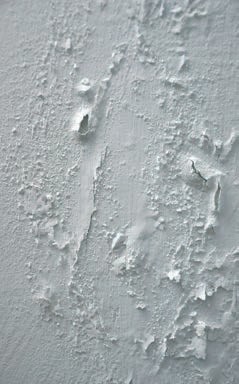 Trwałe uszkodzenia tynku anhydrytowego na skutek dużej wilgotności podłoża.