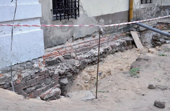 Ściana fundamentowa, mocno profilowana kamieniami i cegłą.