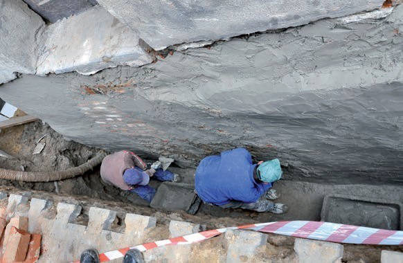 Wyrównywanie ściany fundamentowej z użyciem zaprawy mineralnej.