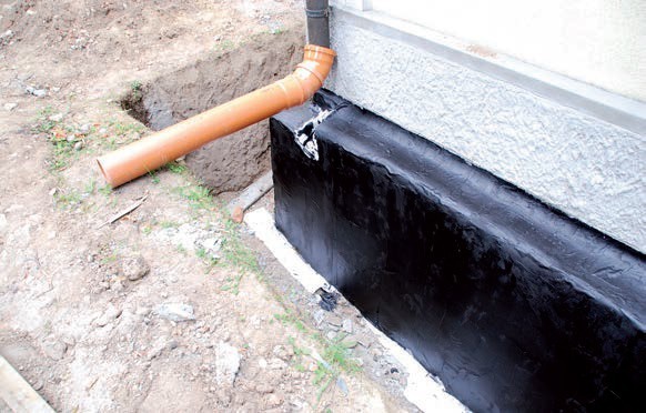 Izolacja bitumiczna COMBIDIC na powierzchni ściany fundamentowej rewitalizowanego obiektu.