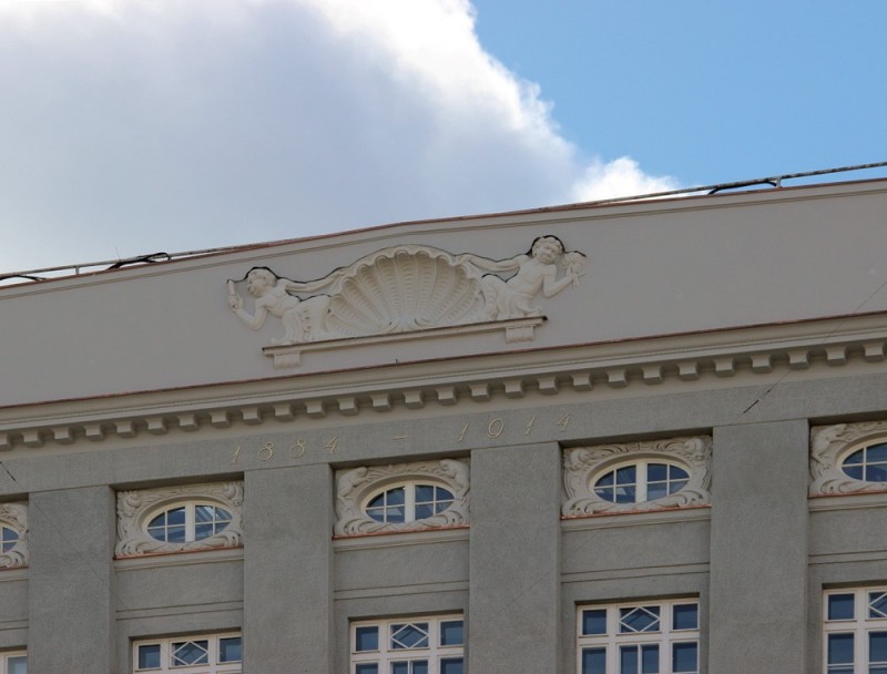 Odrestaurowany gzyms gmachu z szeroką attyką.